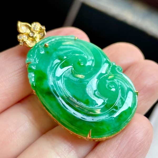 A glutinous ice-green jadeite Ruyi pendant inlaid with gold and diamonds
